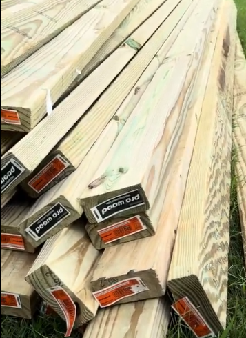 Stacked wooden fence boards ready for installation by Gutter Bro